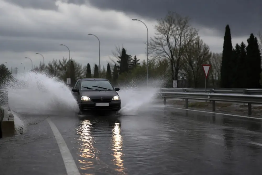 Rueda atravesando una lámina de agua en la calzada