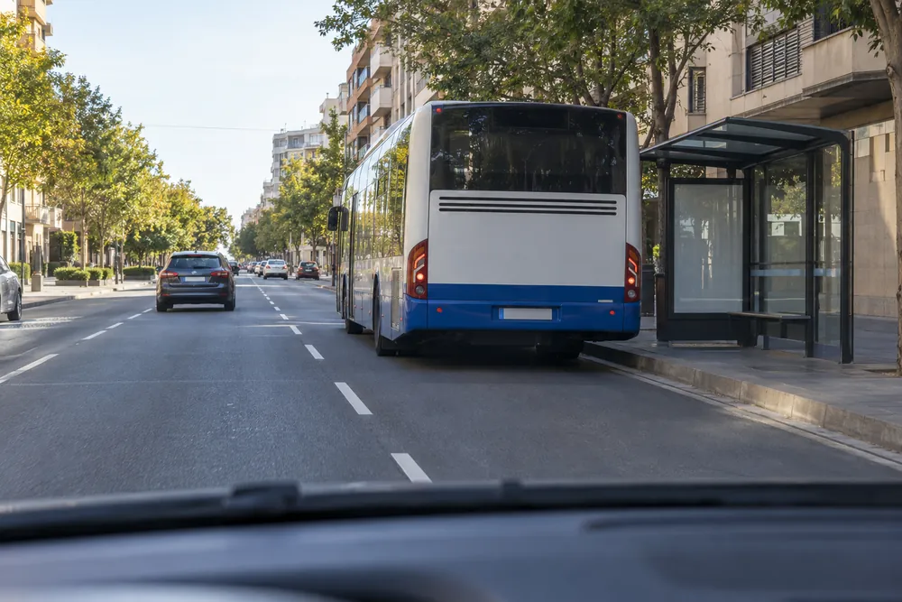 Autobús detenido junto a la acera que oculta a quienes podrían salir.