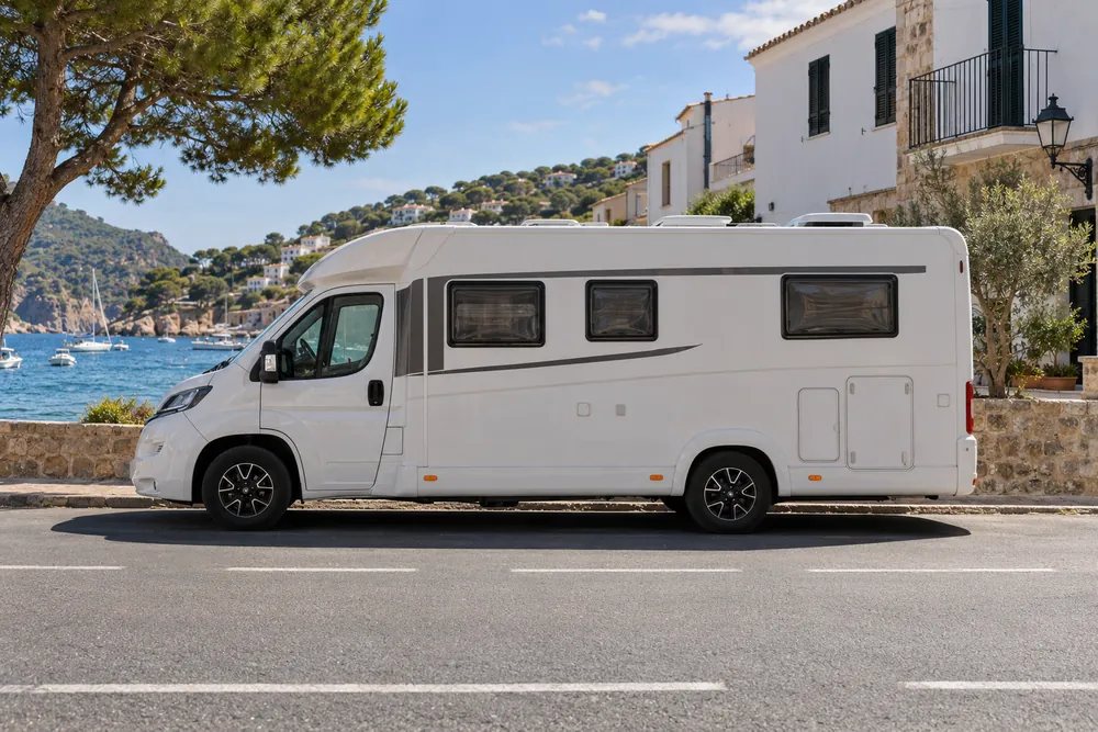 Autocaravana estacionada en una calle de un pueblo costero.