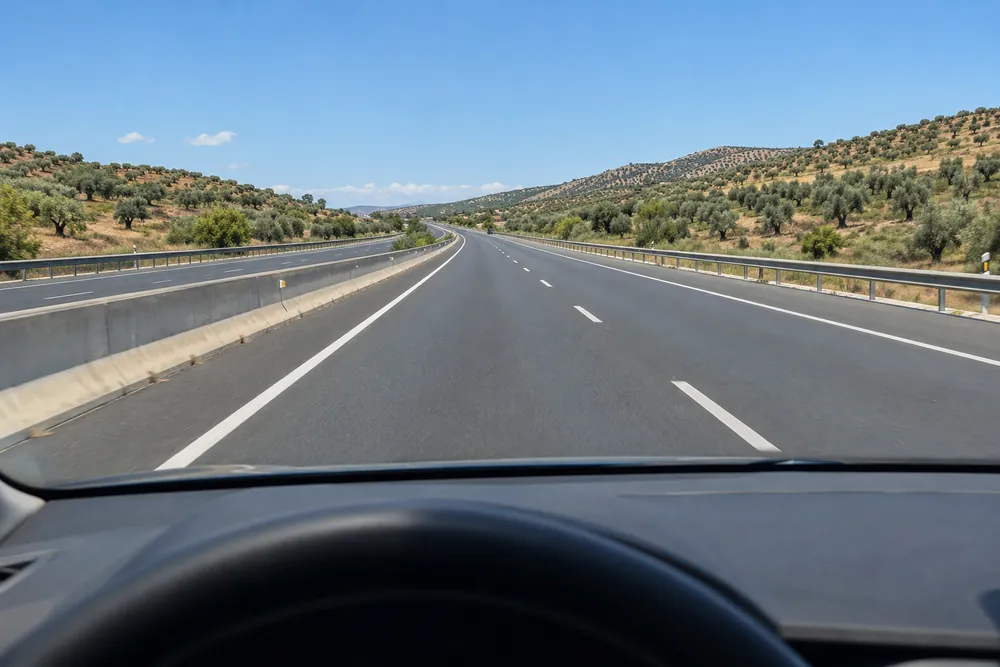 Turismo circulando por el carril izquierdo de una autovía con el carril derecho libre.