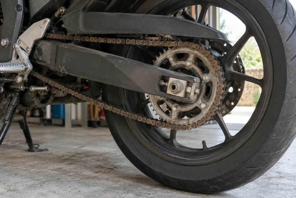 Cadena de transmisión de una motocicleta, seca y algo floja, en un garaje.