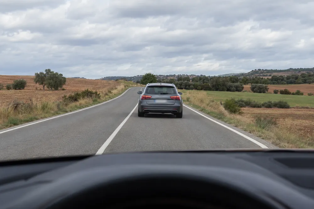 Turismo que se desplaza hacia el centro de la calzada sin intermitente, visto desde el coche que va detrás.