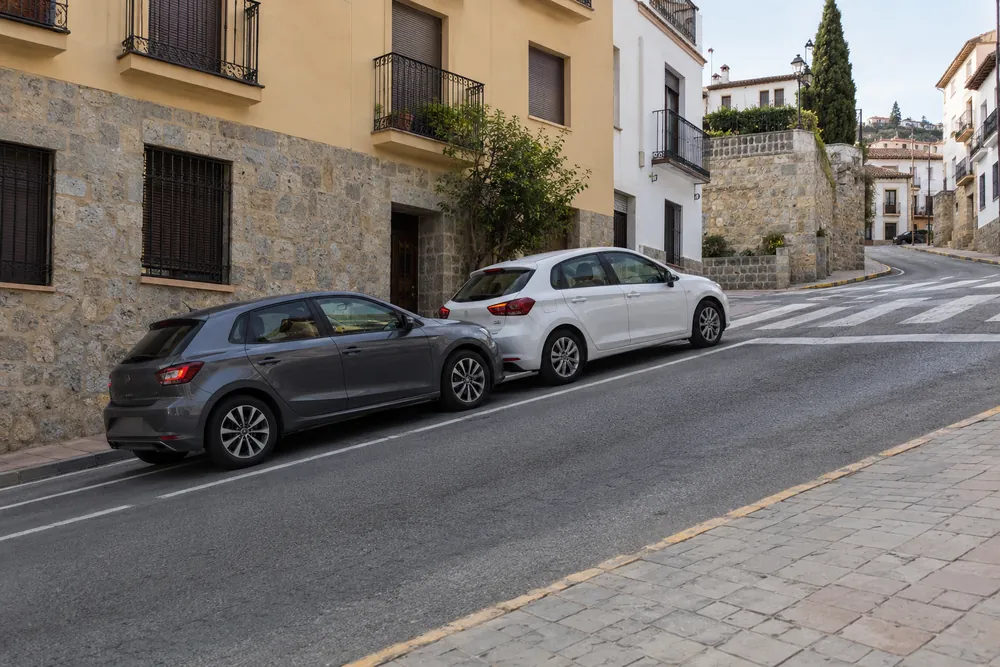 Turismo detenido en una calle muy empinada cuesta arriba, con otro coche pegado detrás.