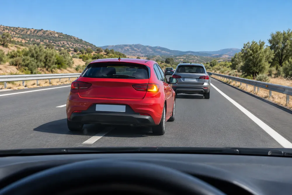 Turismo del carril izquierdo que se mete en el hueco de seguridad por delante, en una autovía.