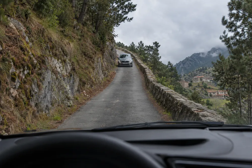 Carretera de montaña estrecha y en cuesta donde un coche que sube y otro que baja no caben a la vez.