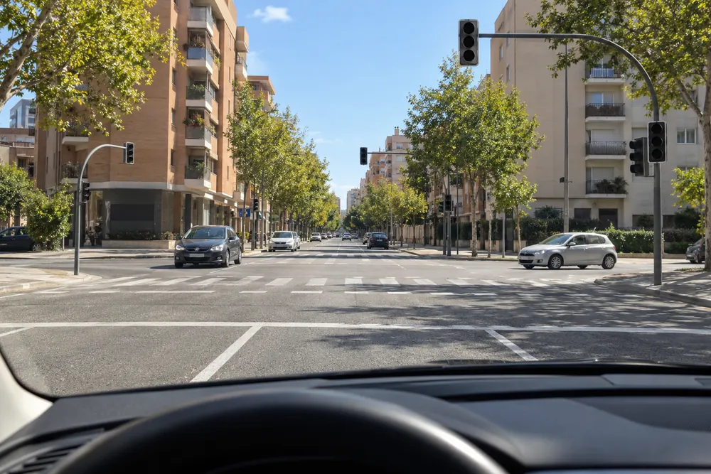 Cruce urbano con los semáforos apagados y vehículos llegando por varias calles.