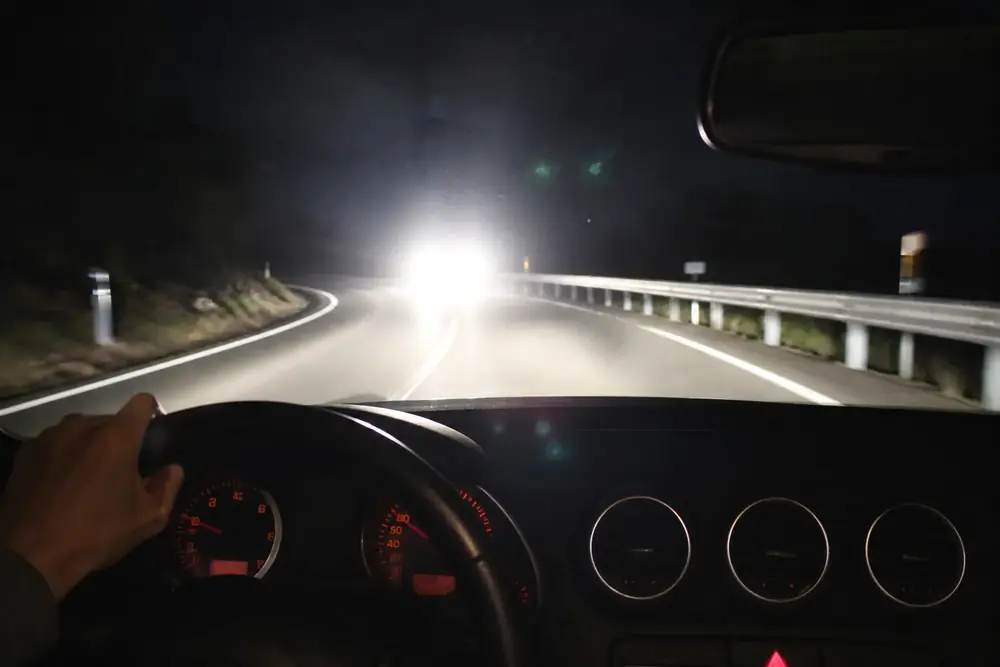 Faros de un vehículo deslumbrando de frente en una carretera nocturna