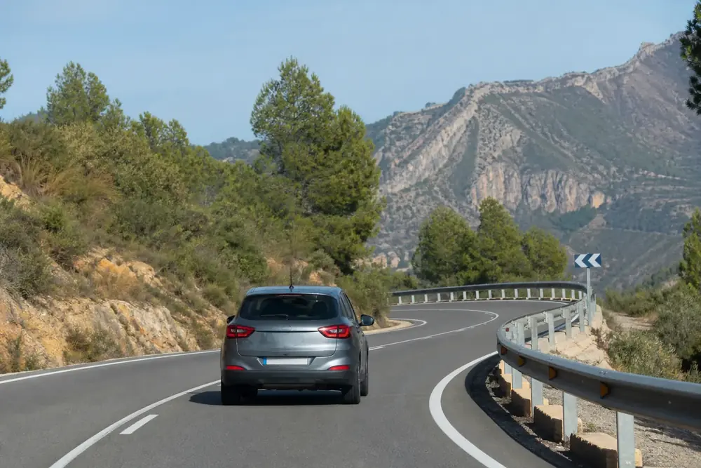Carretera de montaña con curvas encadenadas y barrera metálica