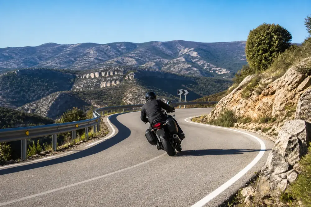 Motorista inclinado en una curva de carretera de montaña