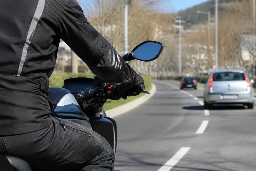 Motorista circulando con el retrovisor y otros vehículos por delante