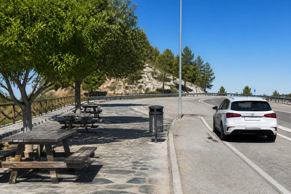 Área de descanso con mesas de merendero junto a la carretera
