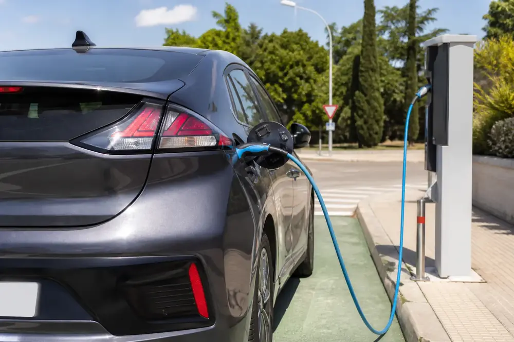 Vehículo eléctrico cargando en un punto de recarga con plaza reservada