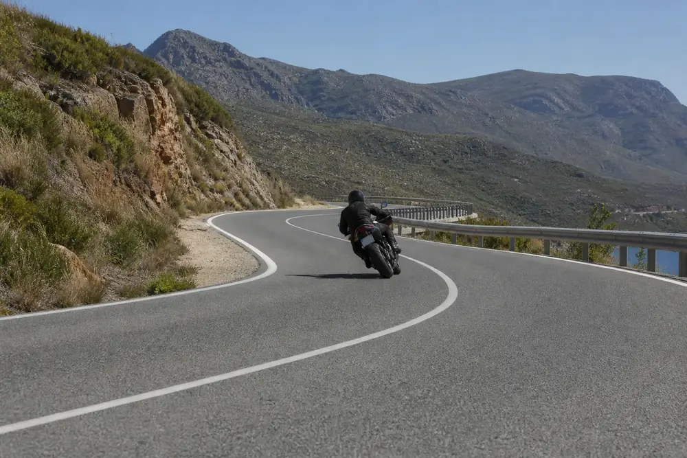 Motorista trazando una curva en carretera de montaña