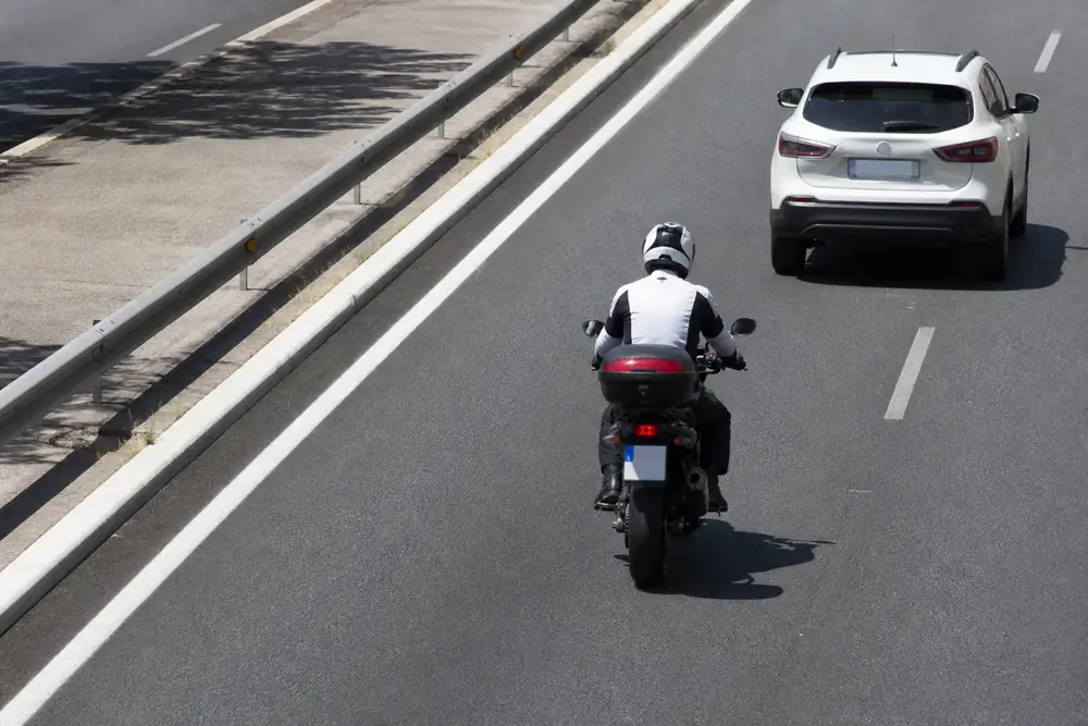 Motorista y turismo circulando por carriles contiguos, vista cenital