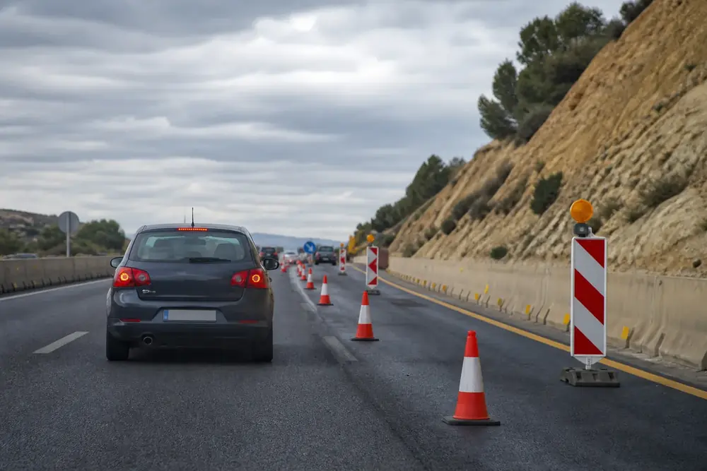 Obras en carretera con conos y balizas que estrechan la calzada
