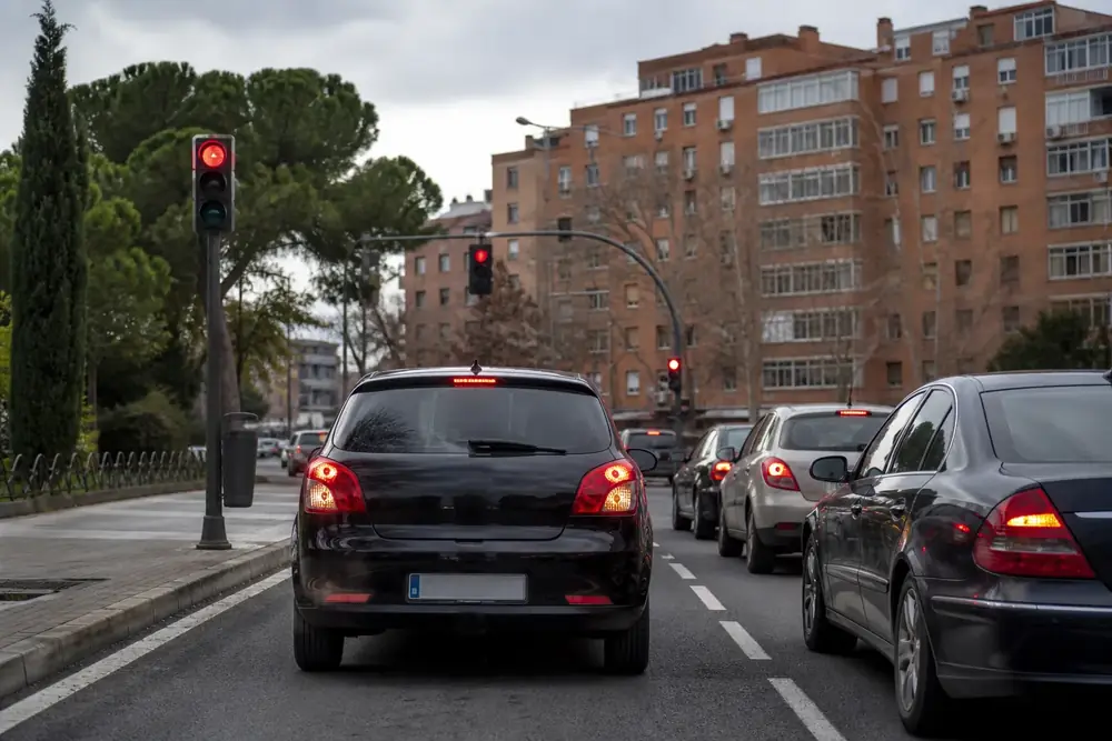 Cruce urbano con el semáforo en rojo y cola de vehículos detenidos