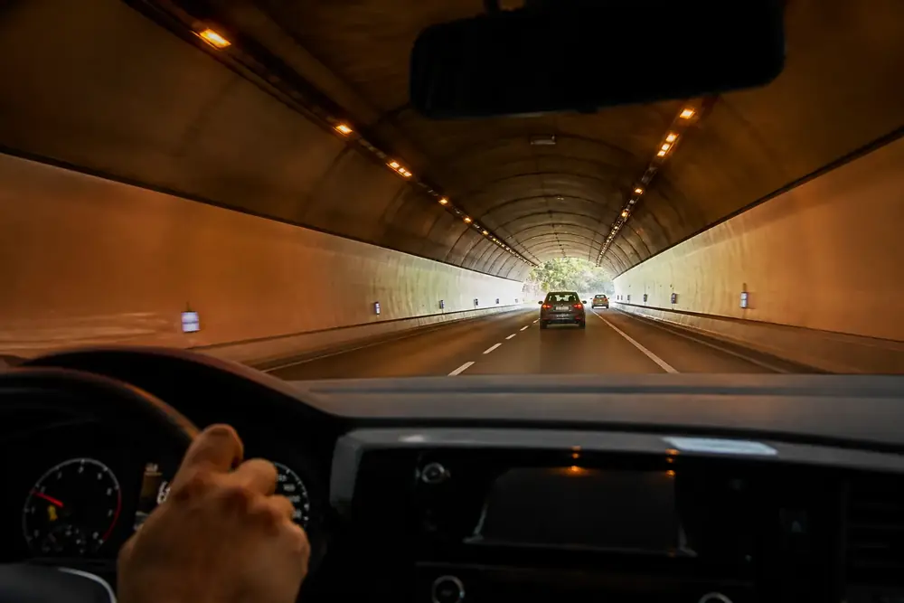 Interior de un túnel iluminado visto desde el puesto de conducción