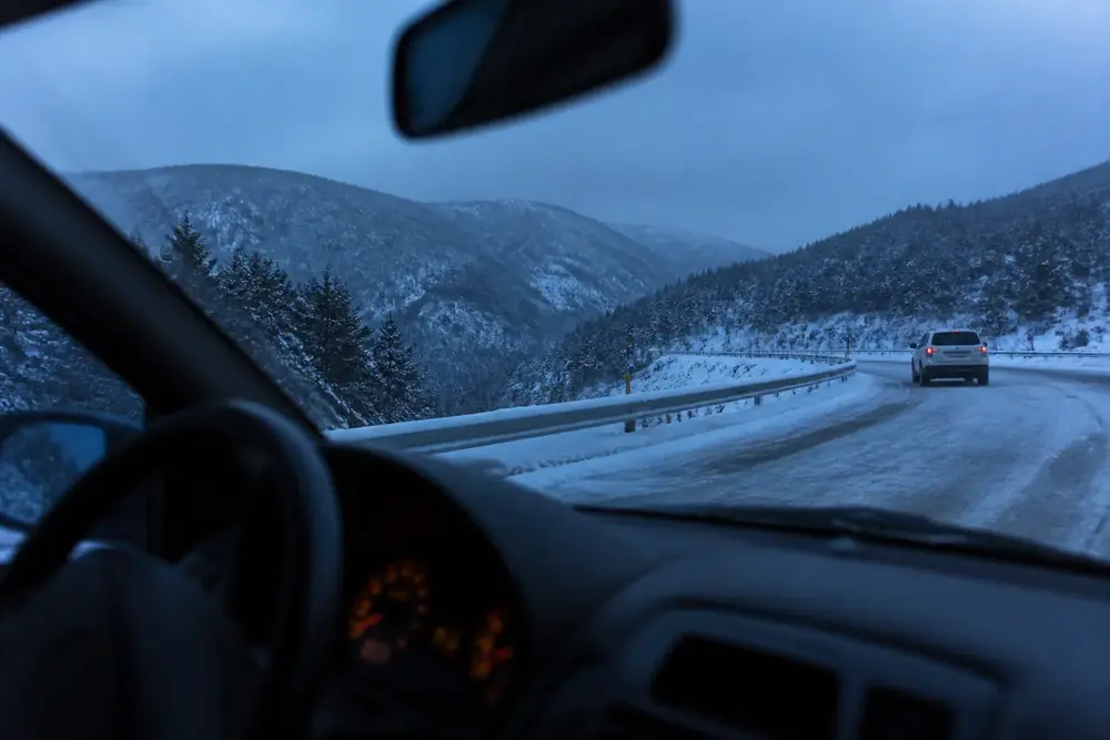 Carretera de montaña nevada vista desde el puesto de conducción