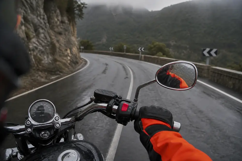 Vista desde el manillar de una moto en carretera mojada