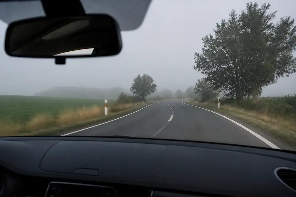 Carretera convencional con niebla vista desde el puesto de conducción