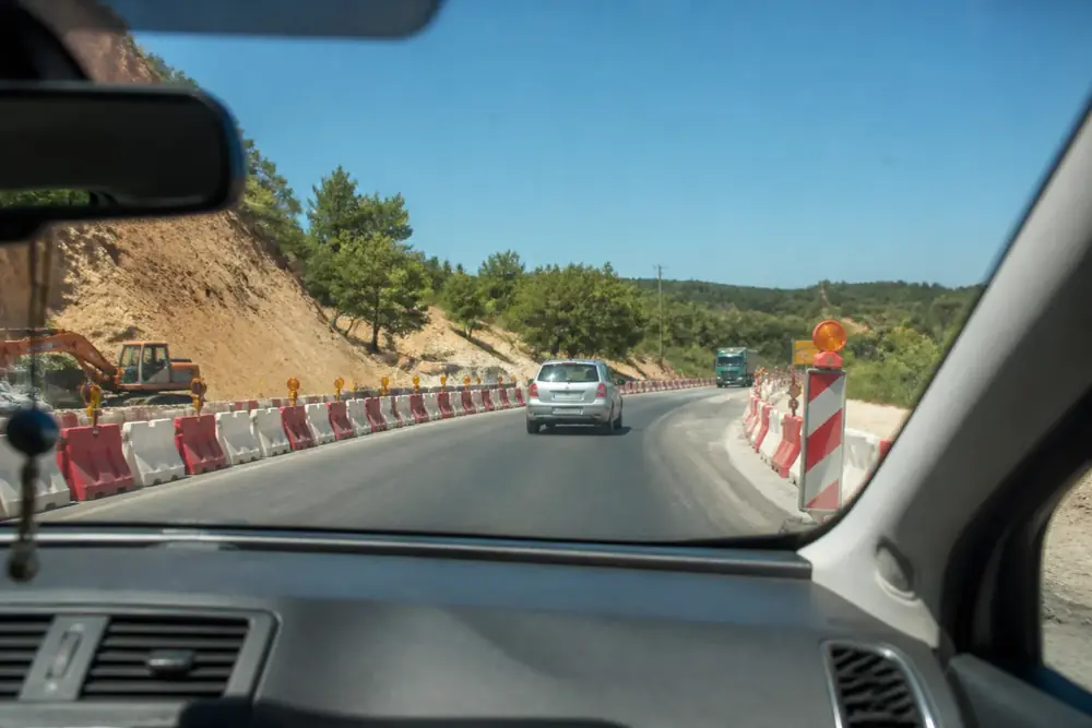 Obras con barreras y maquinaria junto a la calzada