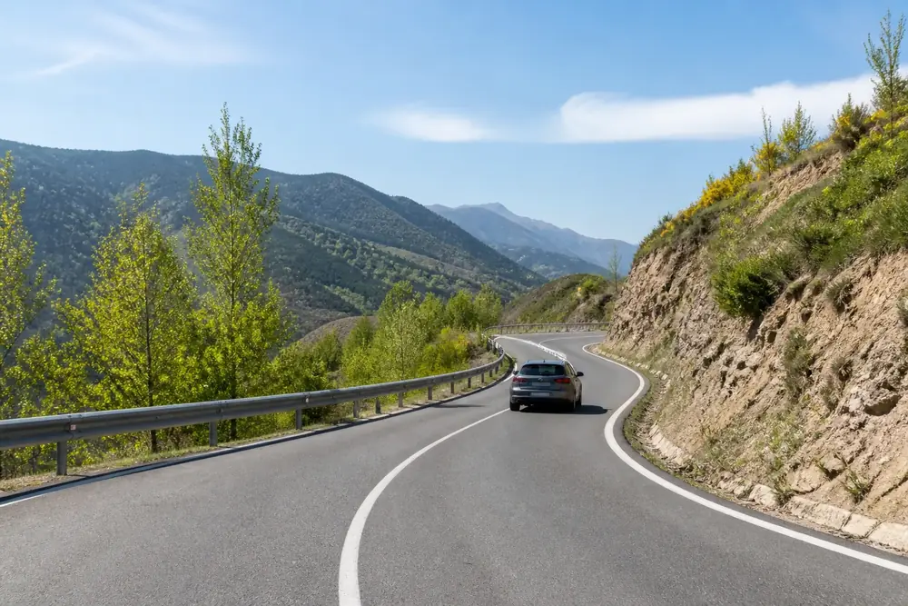 Carretera de montaña con curva y barrera de seguridad