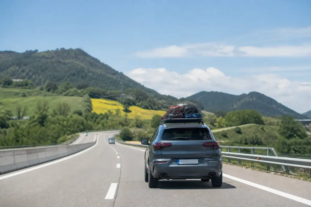Turismo con la baca cargada circulando por autovía