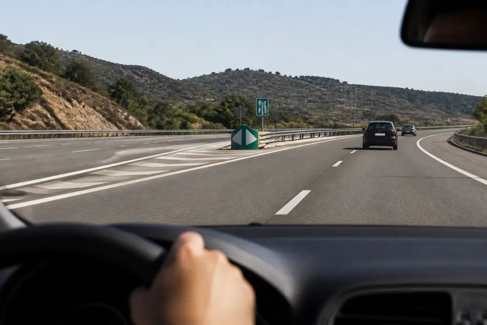 Salida de autovía con panel direccional verde vista desde el volante