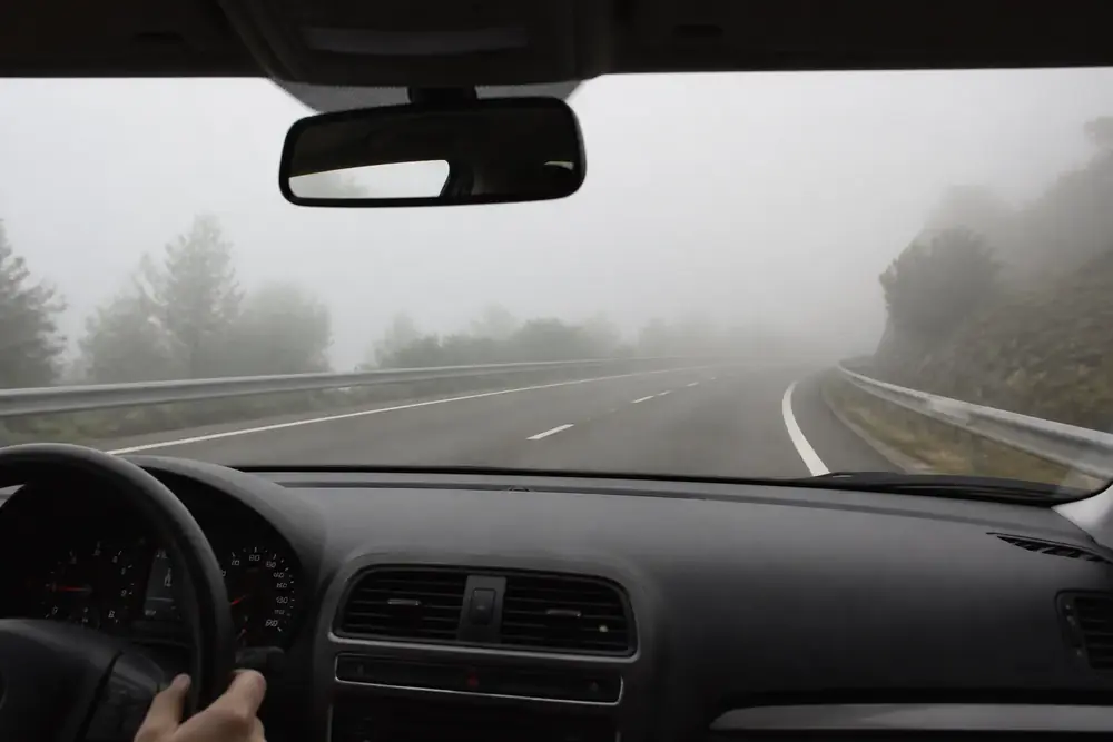 Conducción con niebla por una carretera de montaña