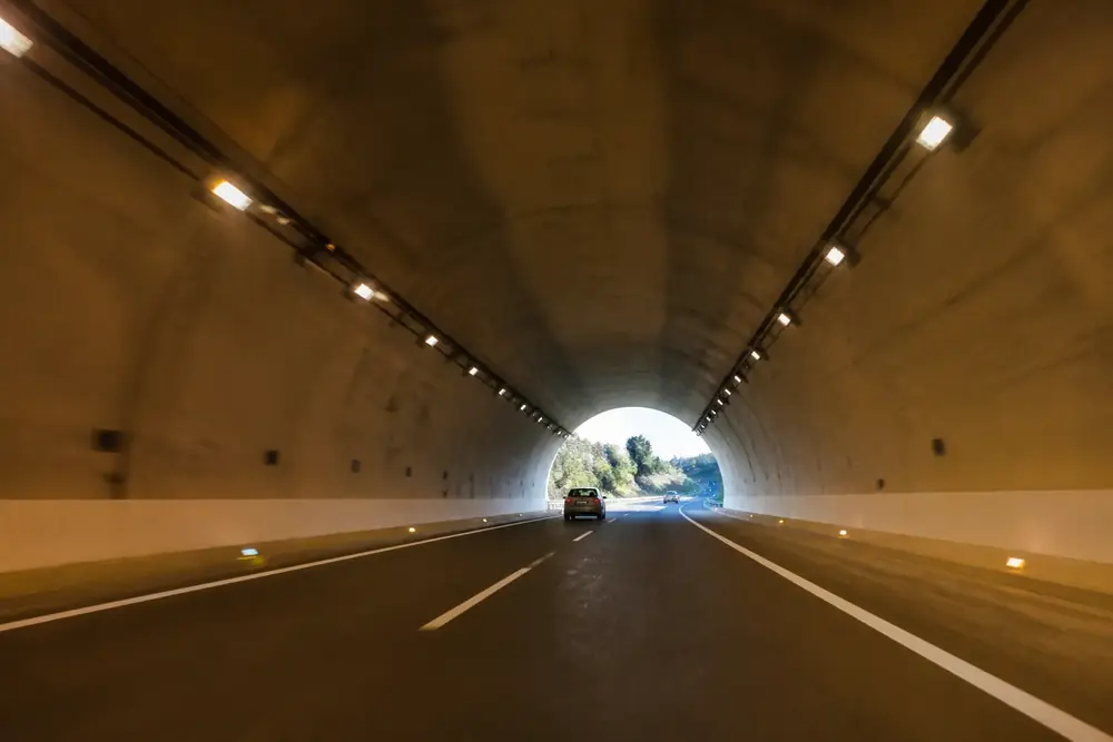 Interior de un túnel con la boca de salida iluminada