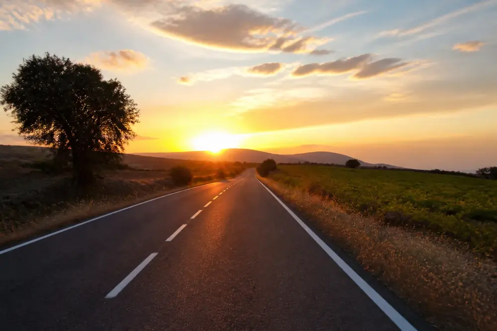 Carretera convencional con la puesta de sol de frente