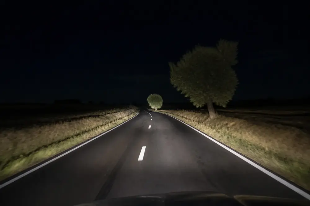 Carretera de noche iluminada solo por los faros del vehículo