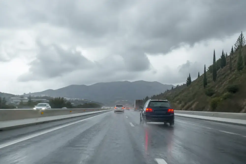 Autovía mojada con tráfico bajo un cielo de tormenta