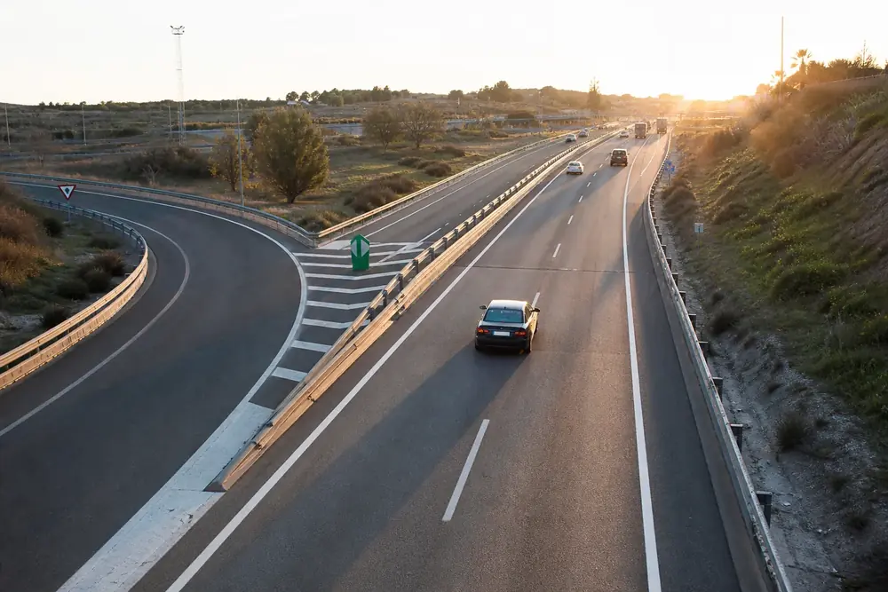 Salida de autovía con cebreado y baliza verde de separación