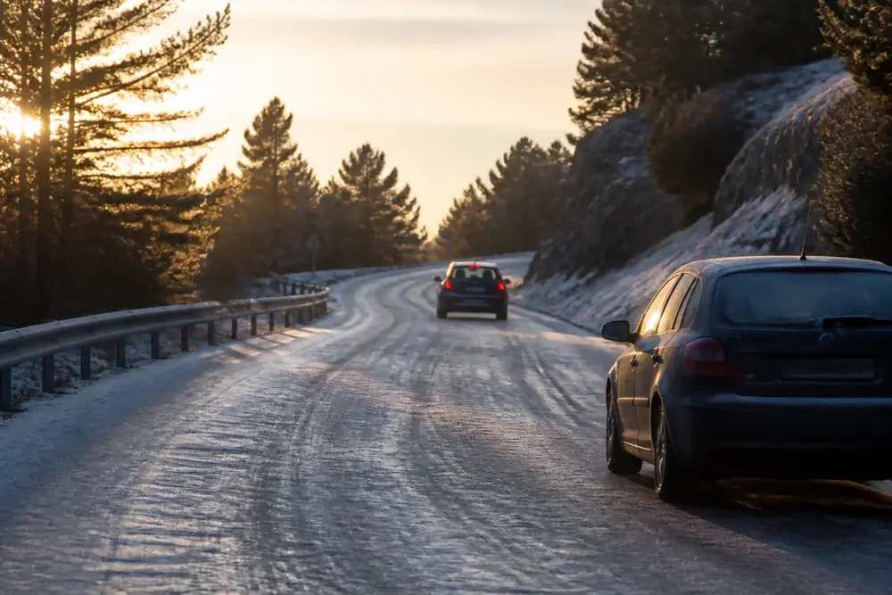 Carretera nevada con vehículos circulando por las roderas