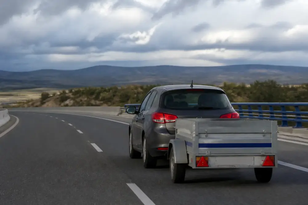 Vehículo con remolque de caja abierta circulando por una carretera