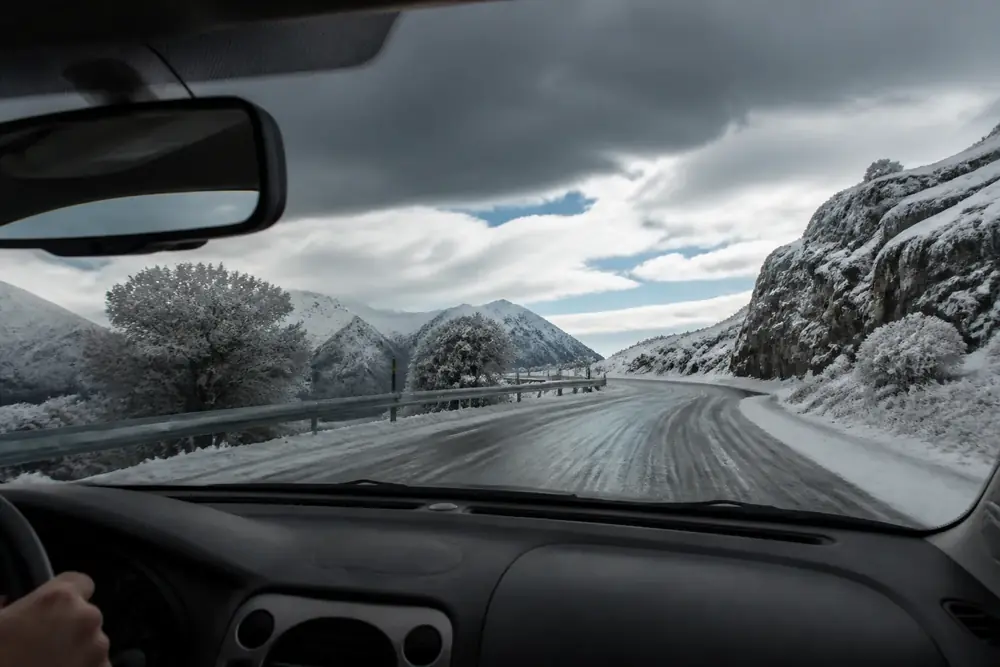 Conducción por una carretera nevada vista desde el volante