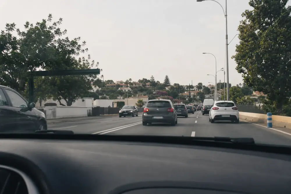 Conducción por una vía urbana con vehículos por delante