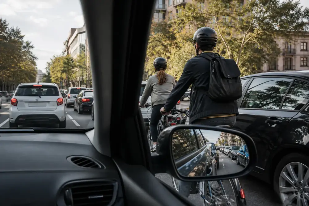 Ciclistas vistos desde el interior del vehículo en una retención