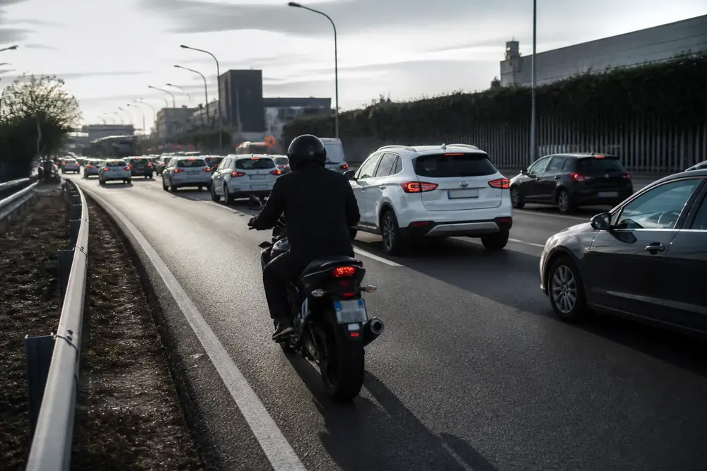 Motorista circulando entre carriles en una autovía con retención