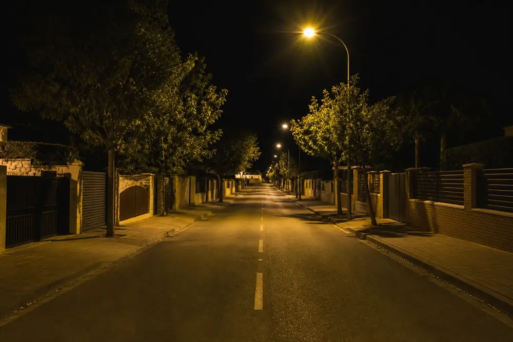 Calle residencial de noche con las farolas encendidas