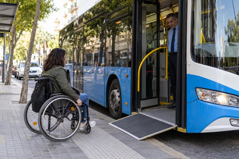 Autobús de piso bajo con rampa y viajero en silla de ruedas.