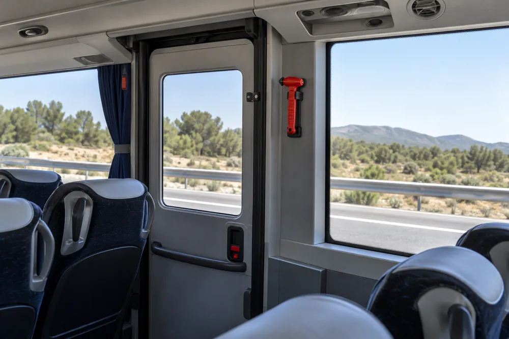 Puerta y martillo de emergencia en el interior de un autocar.