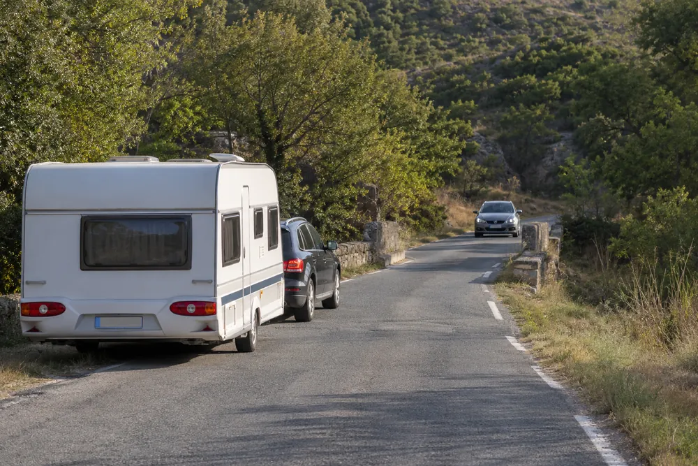 Turismo con caravana ante un tramo estrecho.