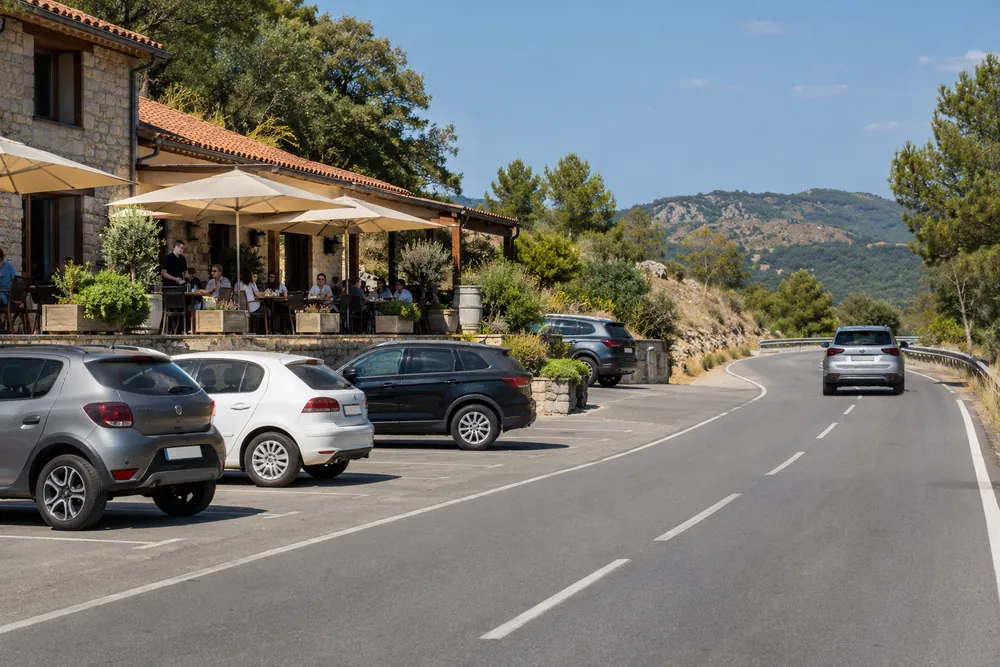 Restaurante junto a una carretera con zona de aparcamiento.