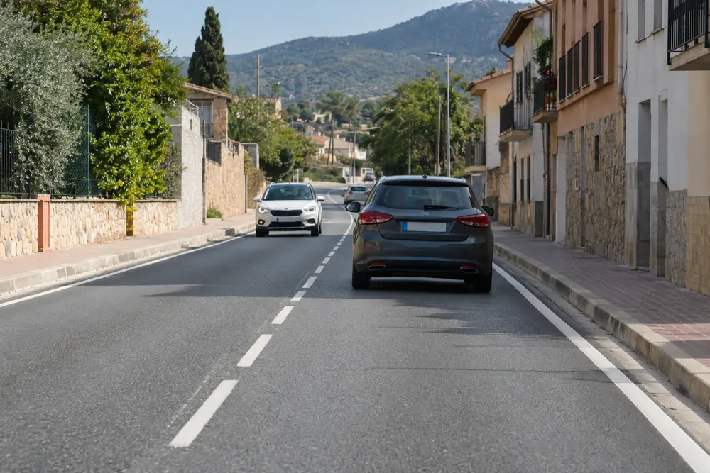 Carretera con arcén pavimentado y acera separada por bordillo.