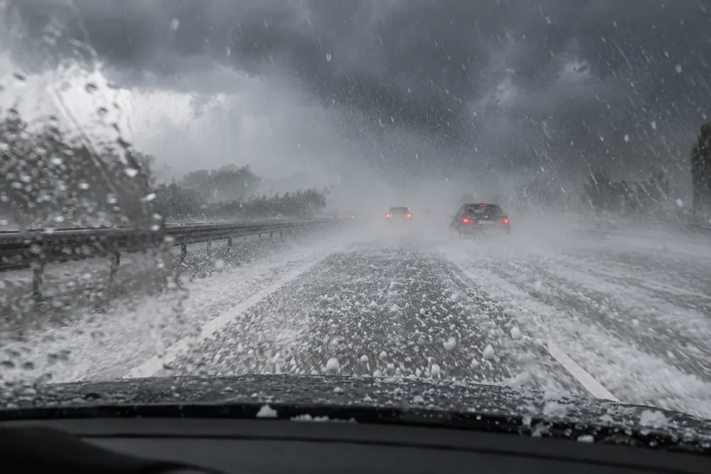 Granizada intensa sobre una autovía, vista desde el interior del coche.