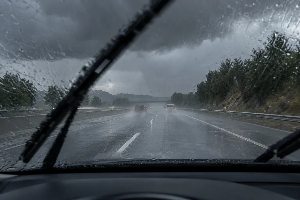 Autovía con lluvia intensa y visibilidad reducida desde el interior del coche.
