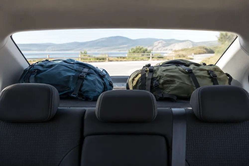 Dos mochilas sueltas en la bandeja trasera de un turismo.
