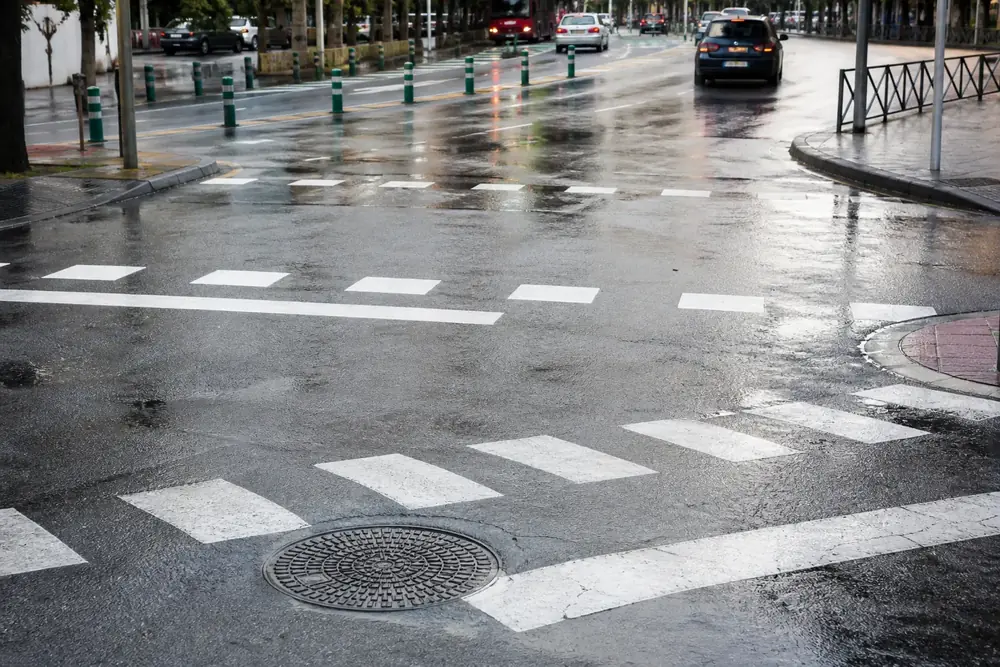Marcas viales pintadas y mojadas en una calzada urbana